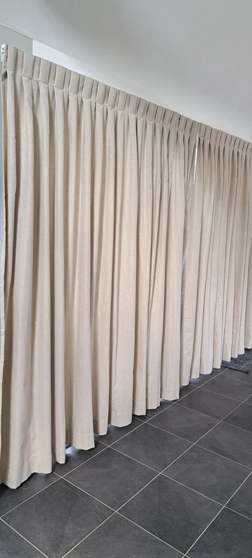 Rideaux sur mesure ivoire à plis réguliers, confection artisanale pour grande baie vitrée